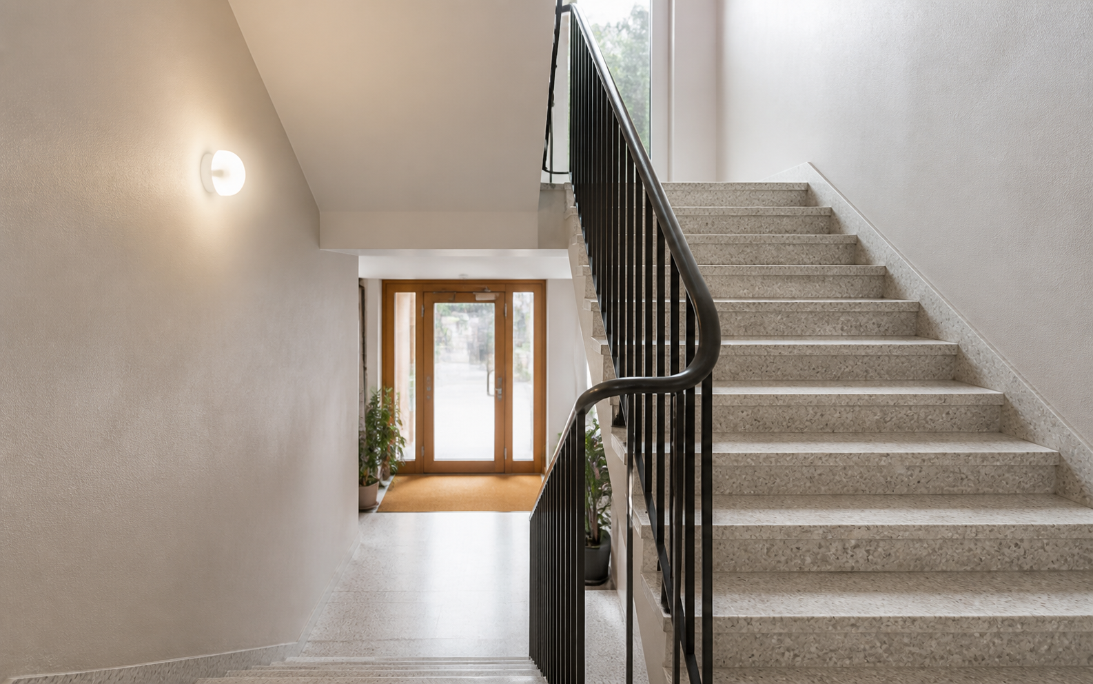 Ljust och välstädat trapphus med terrazzo och ledstång